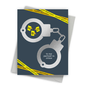 Greeting card with handcuffs and 'Happy Birthday' text on a blue background
