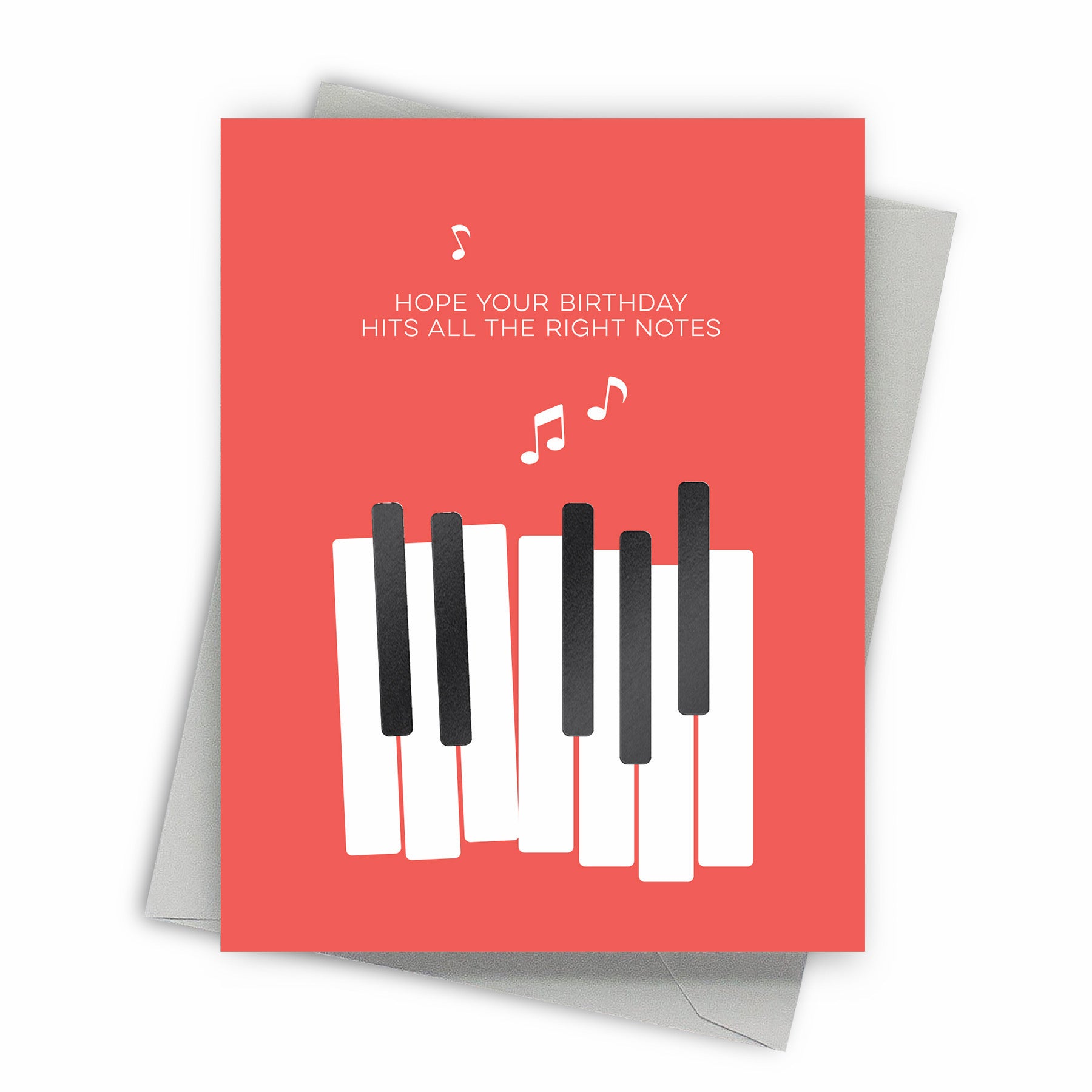 Greeting card with piano keys design and birthday message on a pinkish background