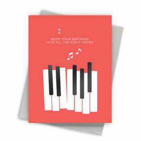 Greeting card with piano keys design and birthday message on a pinkish background