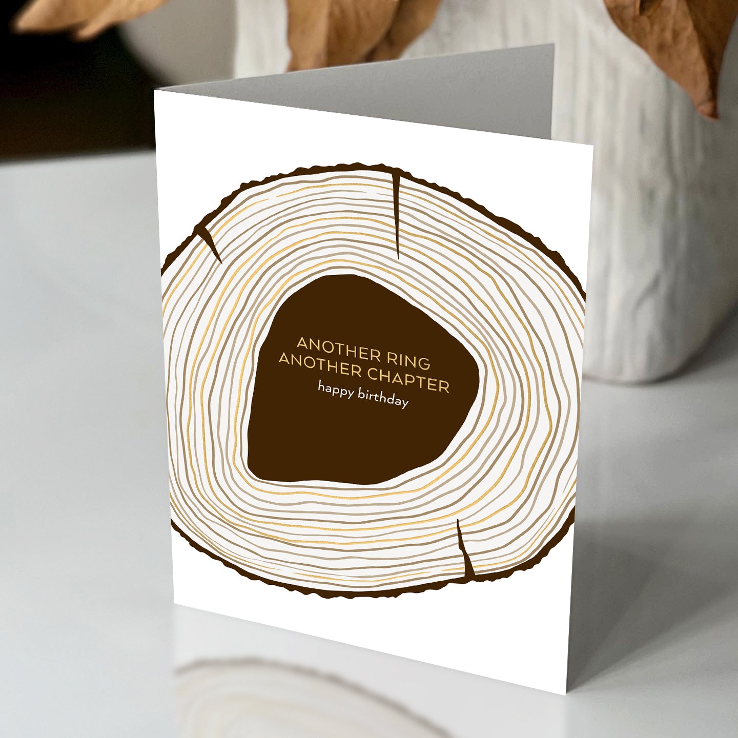 Greeting card with tree ring design and text on a white surface