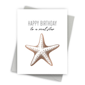 Greeting card with a starfish illustration and text 'Happy Birthday to a real star' on a white background.