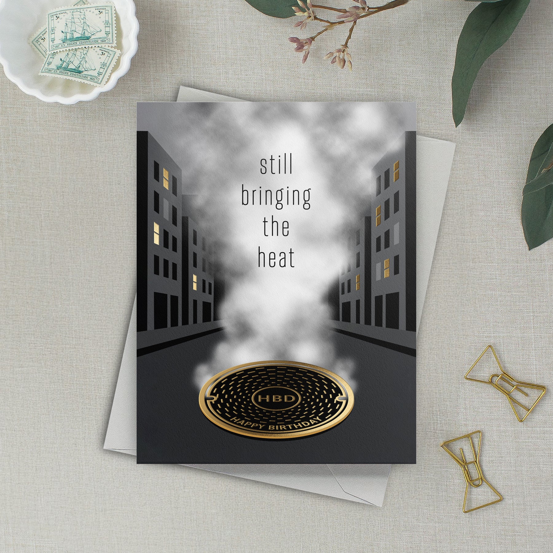 Lifestyle photo of urban themed birthday card that reads "still bringing the heat – Happy Birthday"