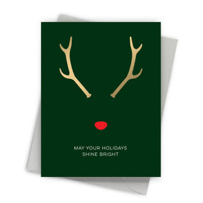 Greeting card with reindeer antlers and a red nose on a green background, featuring the text 'May your holidays shine bright'.